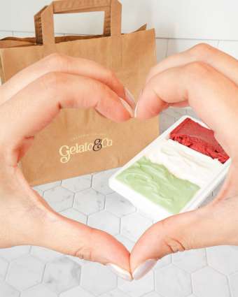 Heart shaped hands framing a gelato tub